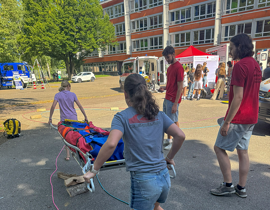Zwei junge Frauen tragen ein Verletztenbahre